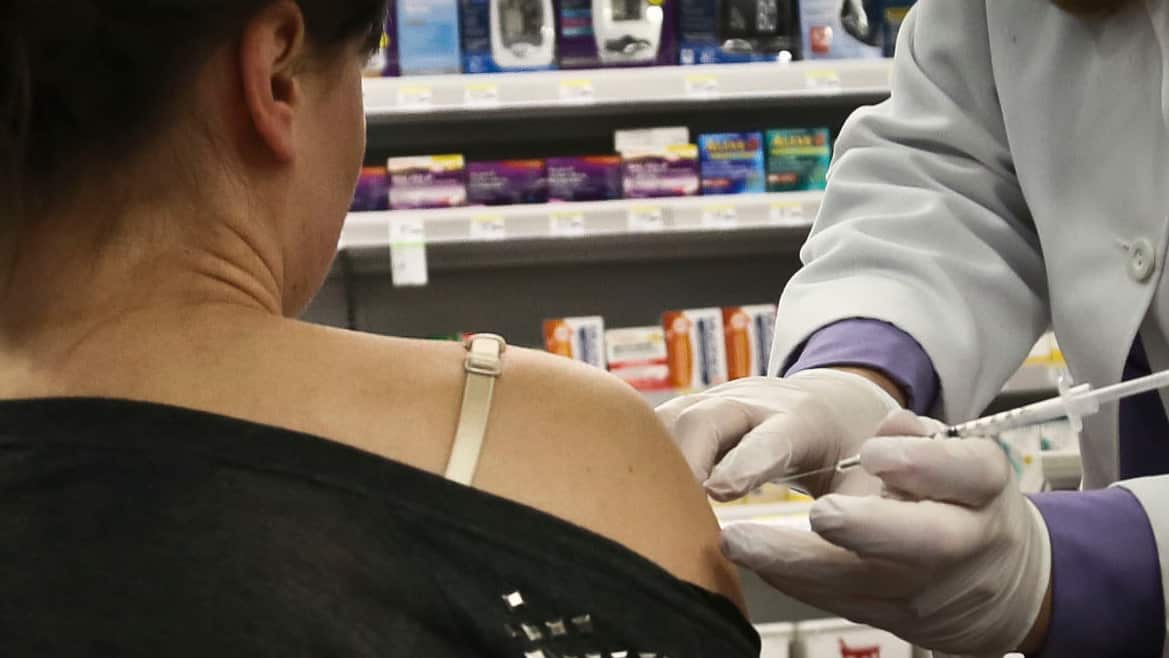 Pharmacist administer a flu vaccine on site.