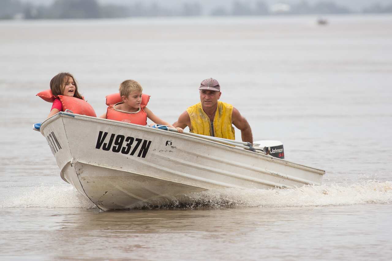 People make their way through flood waters in Maclean, northern NSW, Wednesday, Jan. 30, 2013. About 750 people evacuated from Maclean on Tuesday night have been able to return today, after the Clarence River hit 3.1 metres near Maclean as a result of ex 