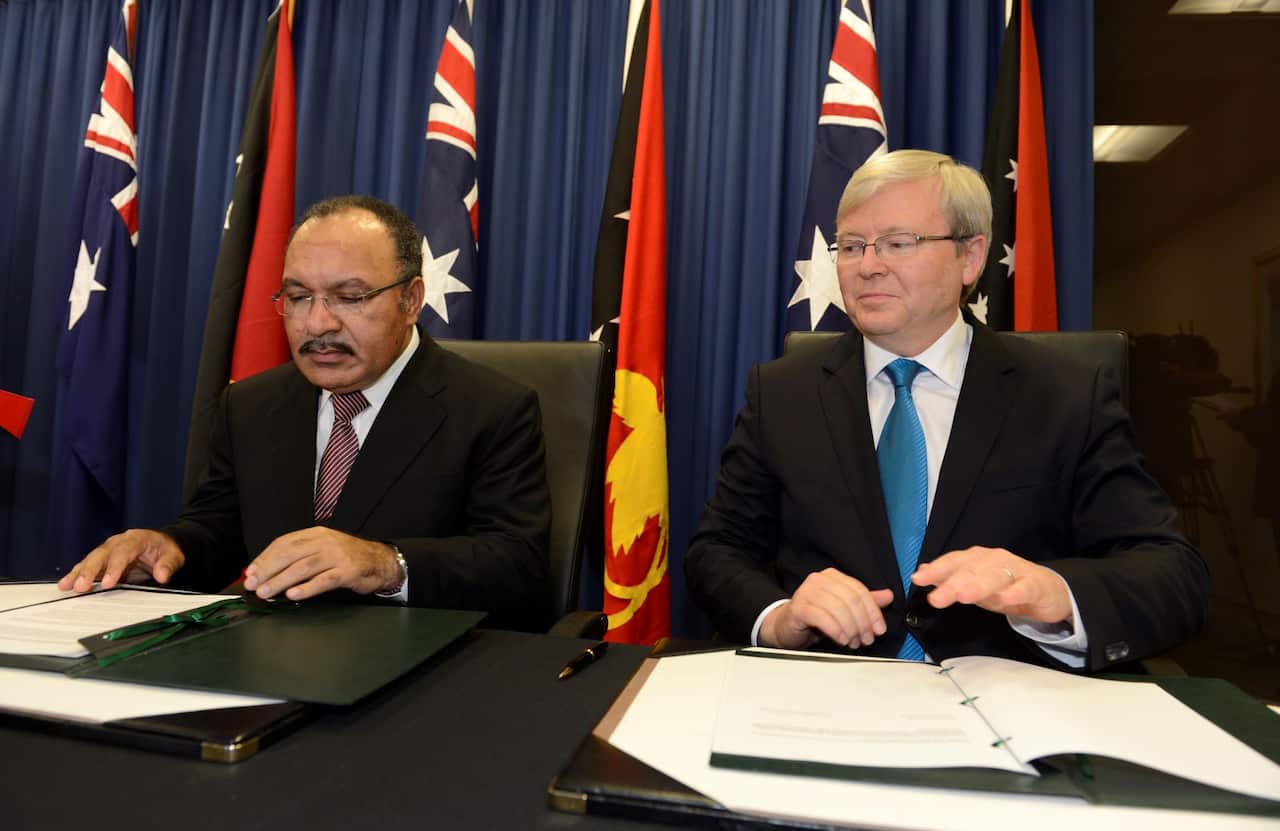 Prime Minister Kevin Rudd (right) and Papua New Guinea Prime Minister Peter O'Neill sign an agreement to deal with asylum seekers in Brisbane, July 19, 2013. 
