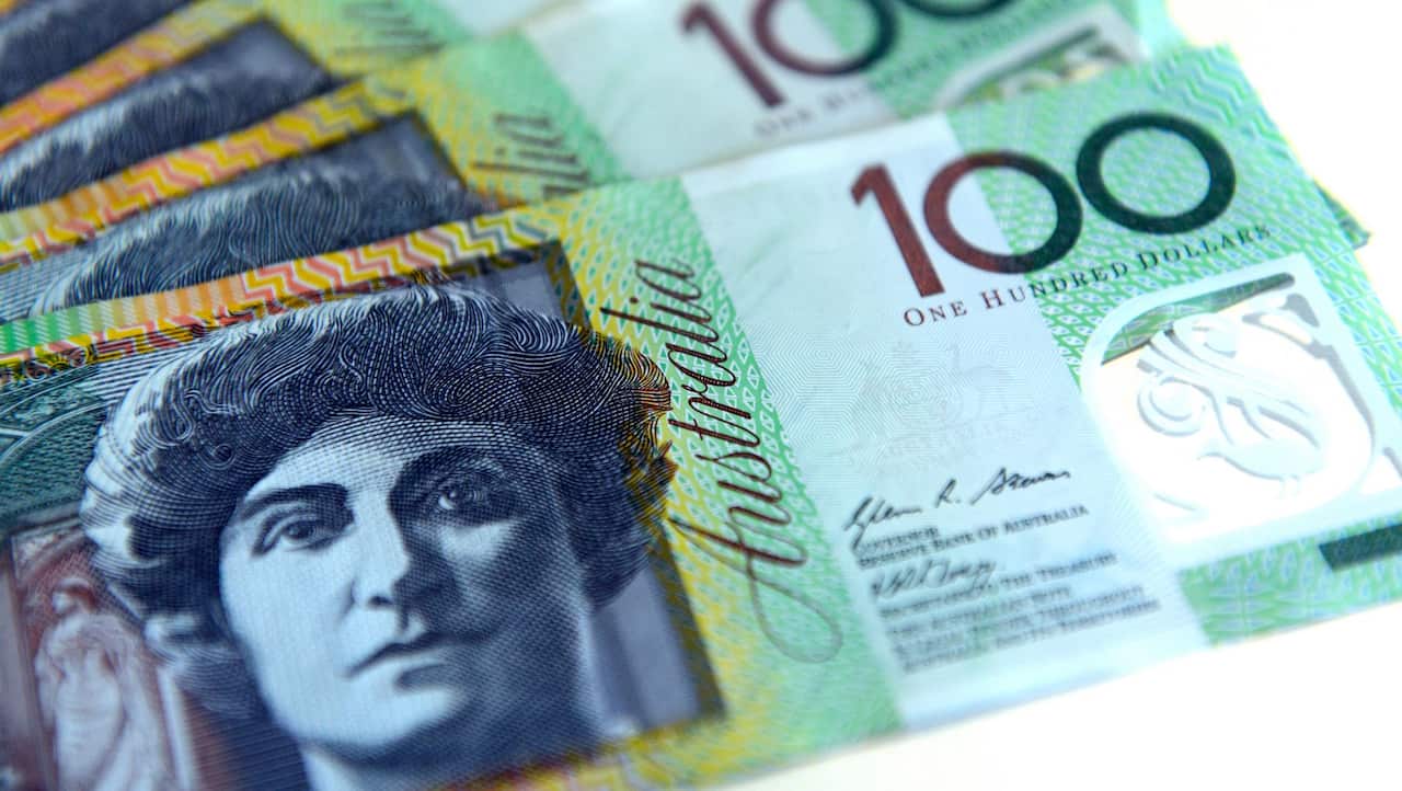 Un hombre regala dinero a trabajadores esperando en fila frente a un Centrelink en Melbourne