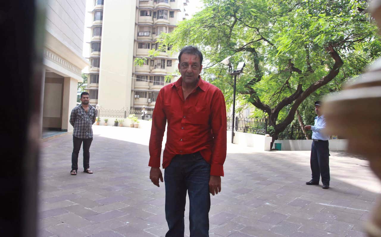 Sanjay Dutt, center, stands outside his home after being temporally freed for two weeks from an Indian prison in Mumbai, India, Tuesday, Oct.1, 2013.