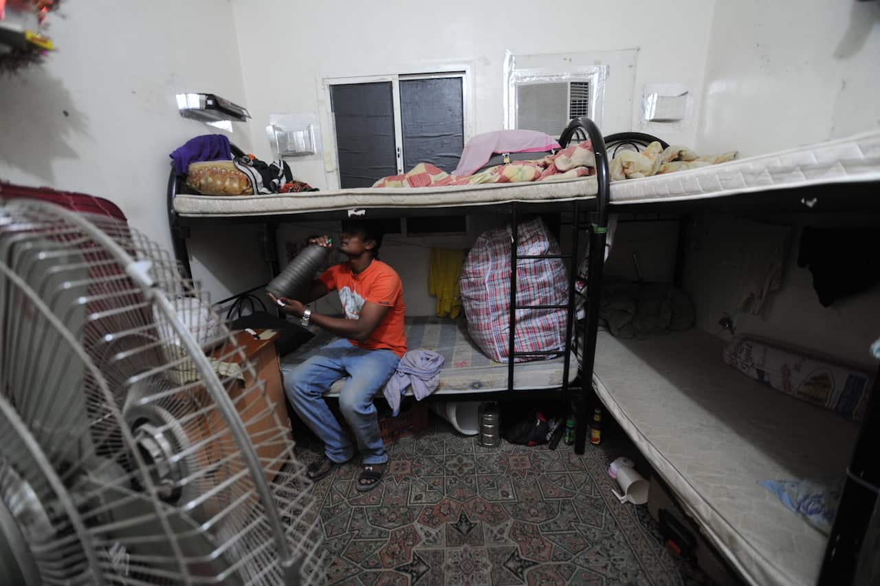 An Amnesty International handout photo shows a migrant worker sitting on a bunk bed in his accommodation in Qatar. Migrant Worker