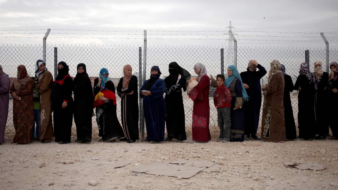 Syrian refugee women stand in line to receive their families share of winter aid kits at Zaatari refugee camp, near the Syrian border, in Mafraq, Jordan.