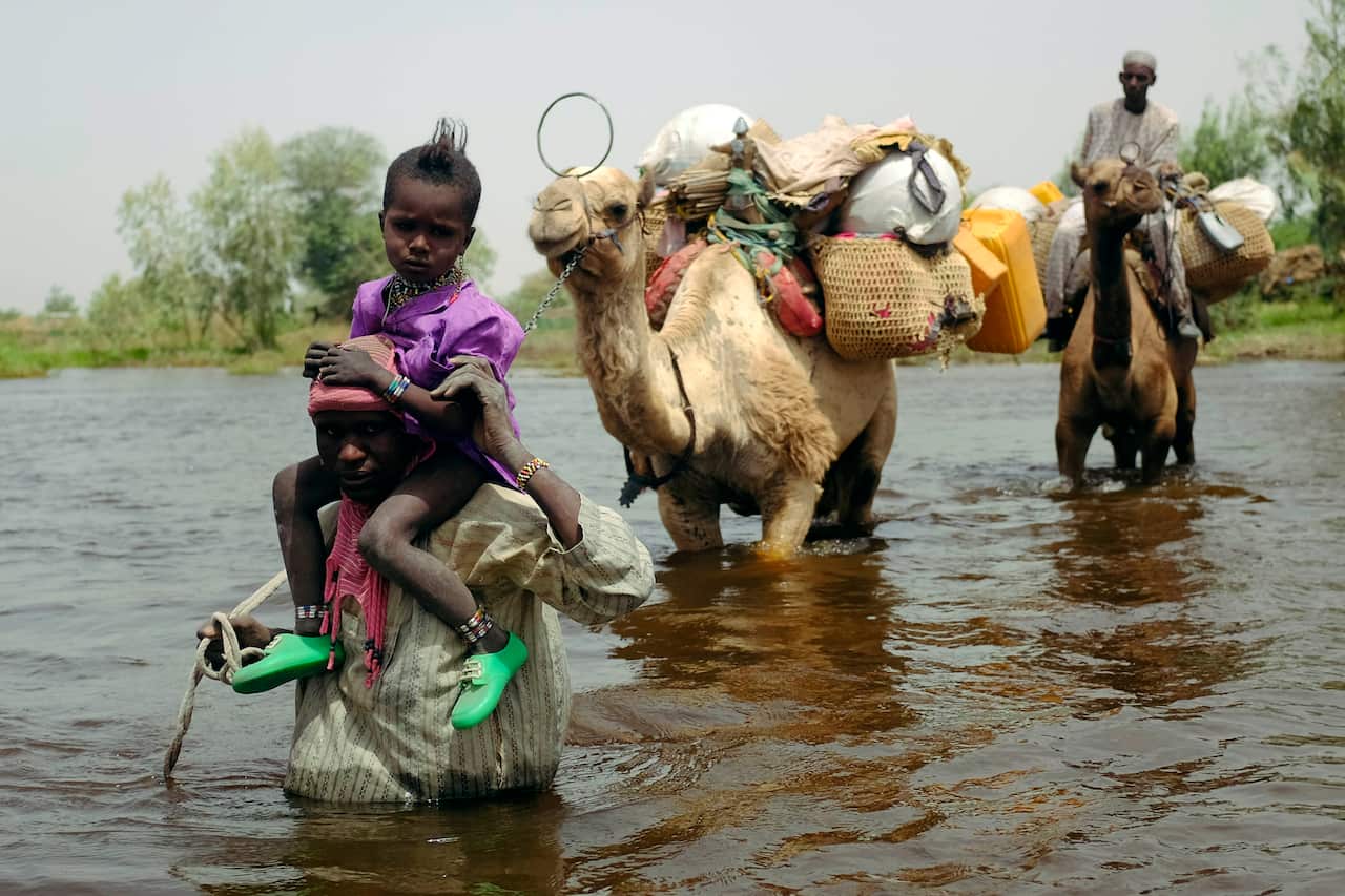 Herdsmen and others cross a tributary of Lake Chad to the village of  N'Gouboua, Chad.