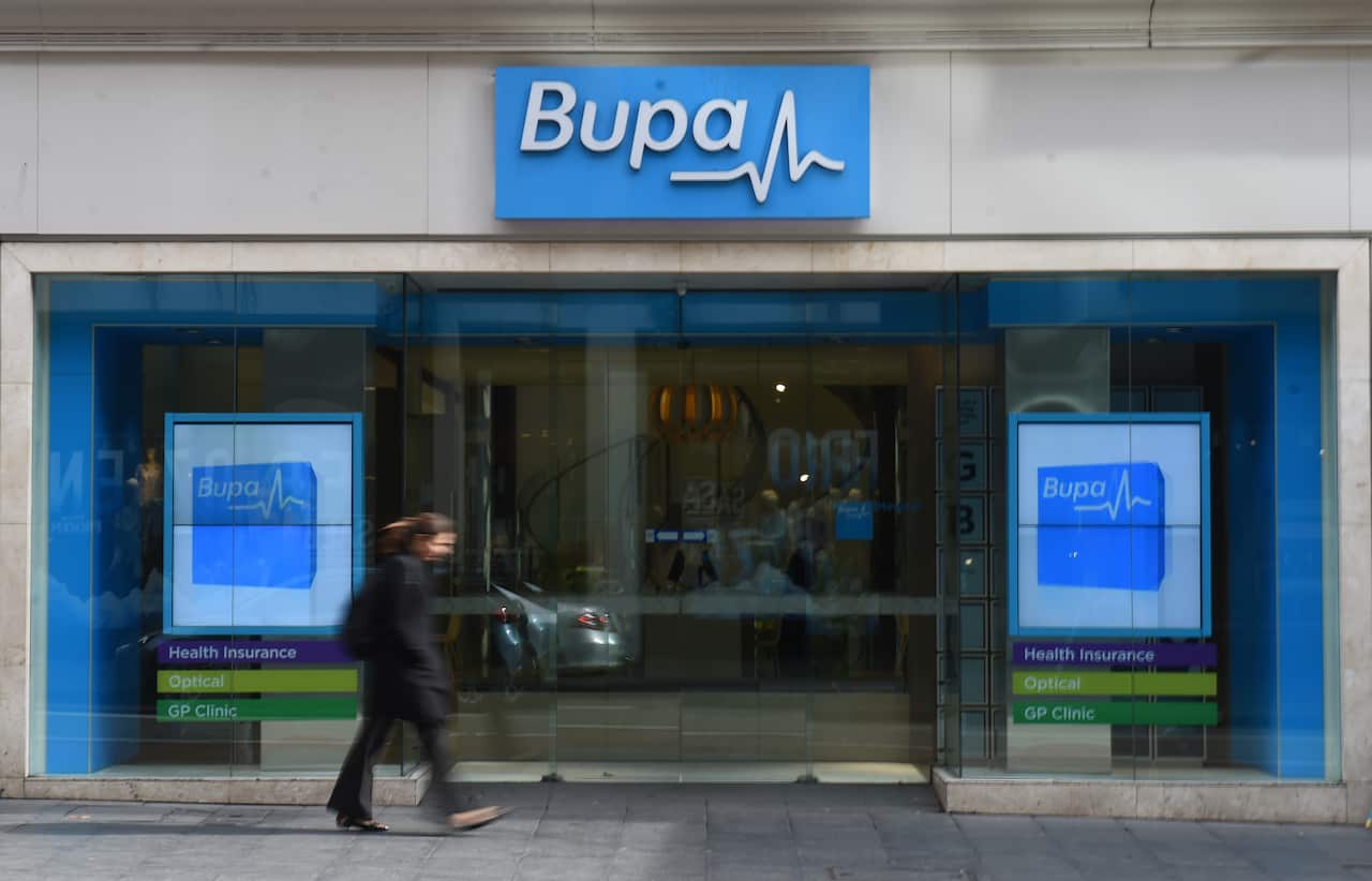 A woman walks past a Bupa Health Insurance branch in Sydney, Monday, July 13, 2015.  (AAP Image/Mick Tsikas) NO ARCHIVING