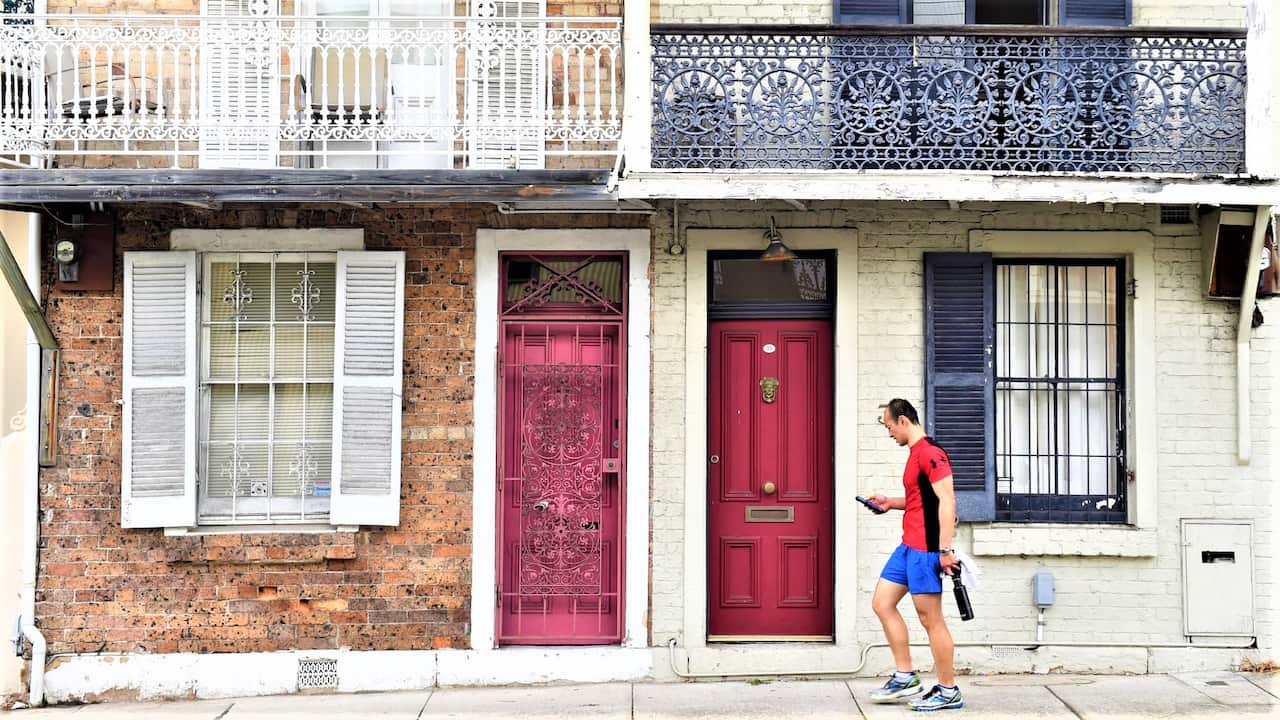 A man walks past some residential houses in Sydney.