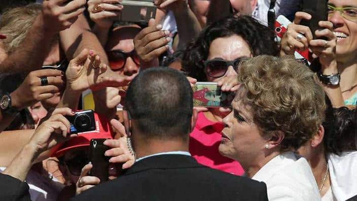 Brazilian President Dilma Rousseff, center, greets supporters as she leaves Planalto president palace in Brasilia, Brazil, Thursday, May 12, 2016. (AAP) 