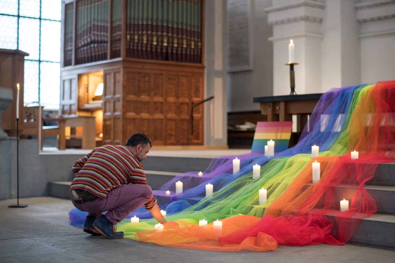 A mourner places his candle as Swiss LGBT activists hold a vigil for those killed and wounded in the Sunday mass shooting at a gay nightclub in Orlando