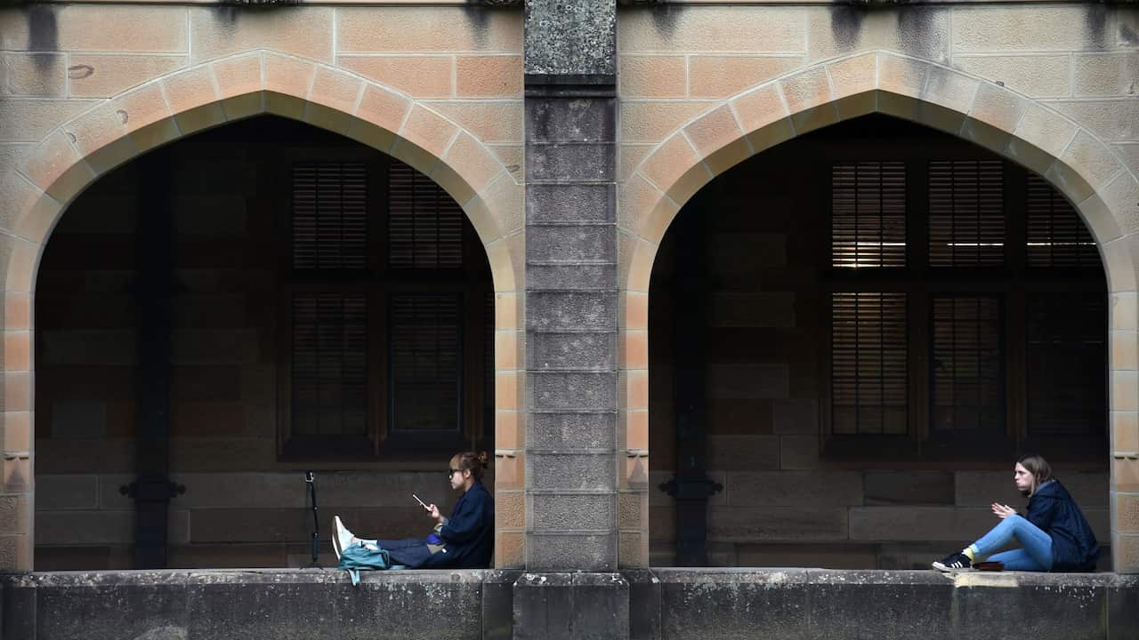 Students sit next to the quadrangle at the University of Sydney,