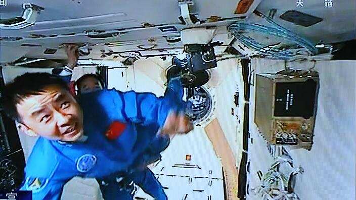 This TV grab shows Chinese astronauts Jing Haipeng, back, and Chen Dong in China's space lab Tiangong II (Tiangong-2), 19 October 2016.