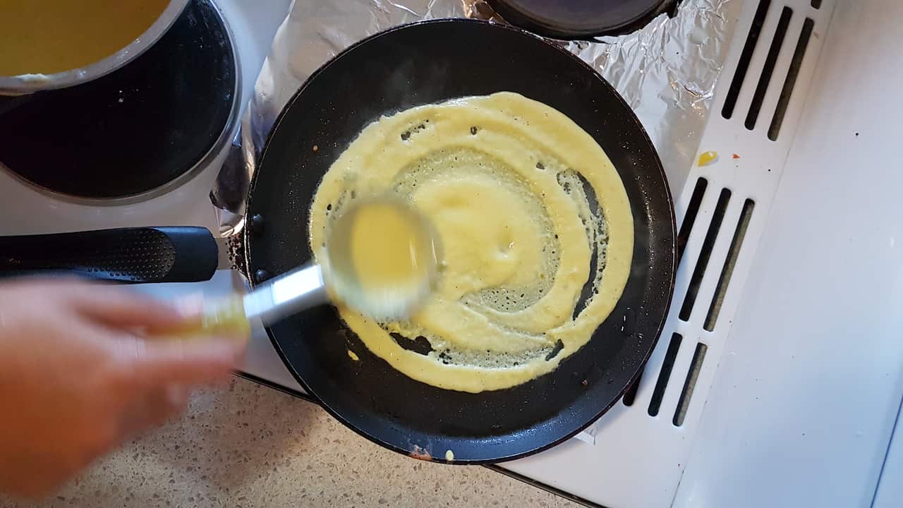 With the cooking spoon spread the batter in a circular shape