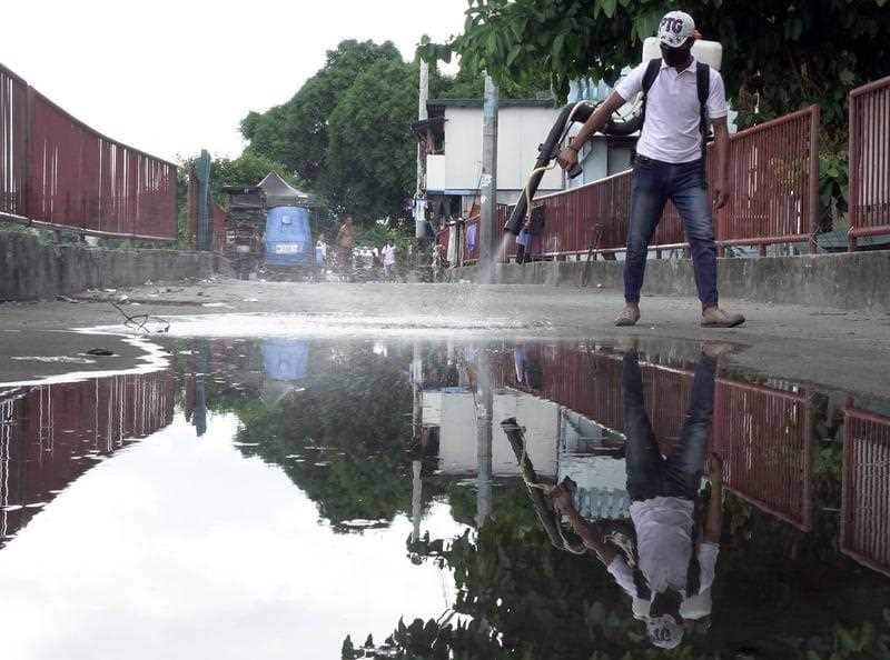 A Filipino pest exterminator sprays chemicals to eradicate mosquitos as part of intensive anti-dengue campaign of the Pest Exterminators Association of the Philippines (PEAP) at a slum area in Manila, Philippines