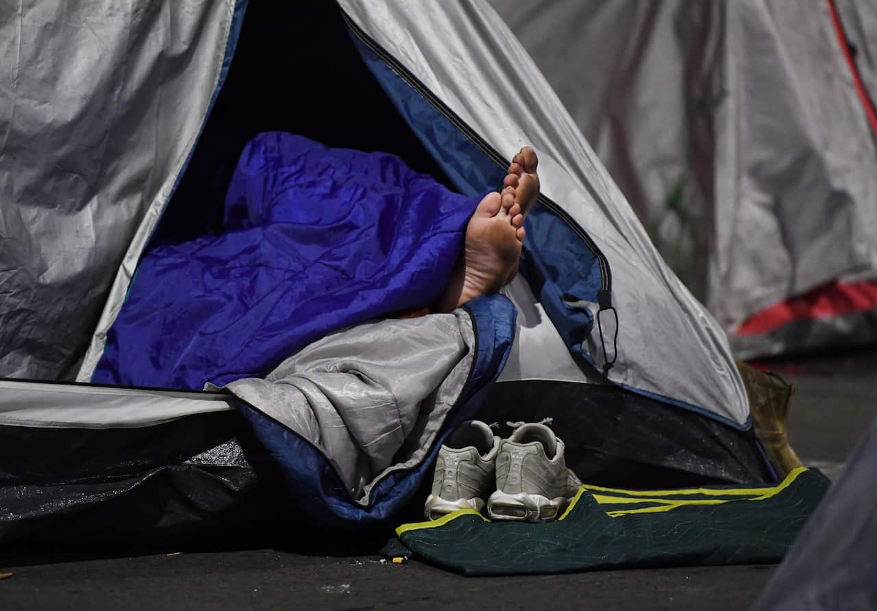 A pair of feet stick out of a tent used by a homeless person in Martin Place in Sydney's Central Business District, Sunday, August 6, 2017. Dozens of tents have been erected since December with the number continuing to grow despite attempts by authorities