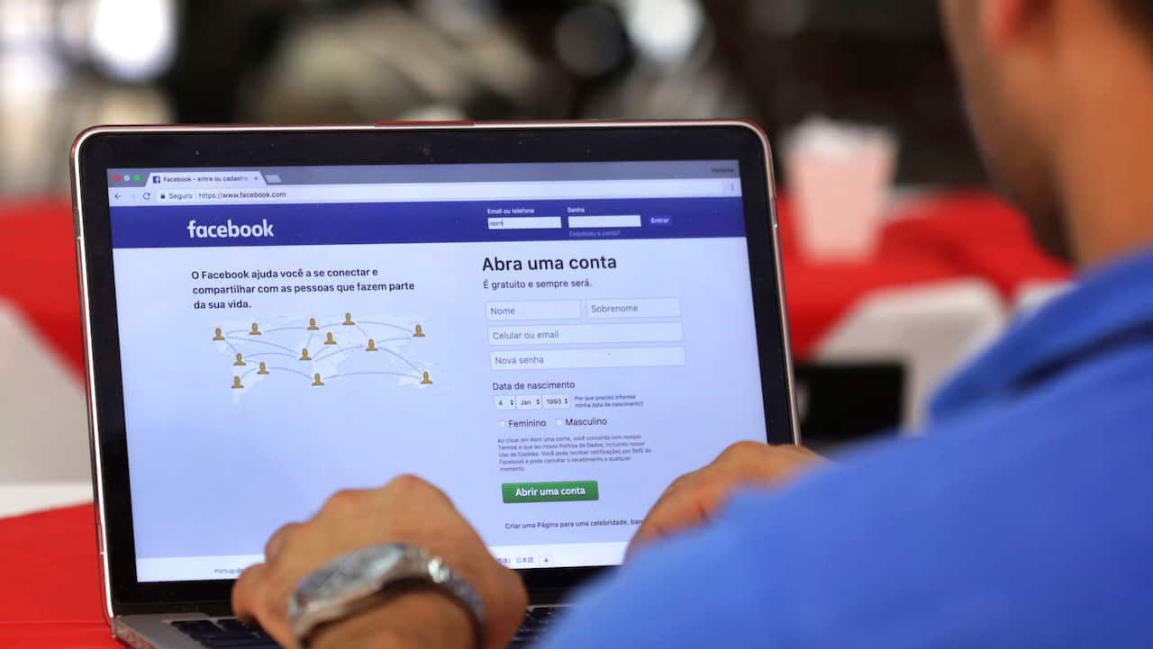 A man demonstrates how he enters his Facebook page as he works on his computer.