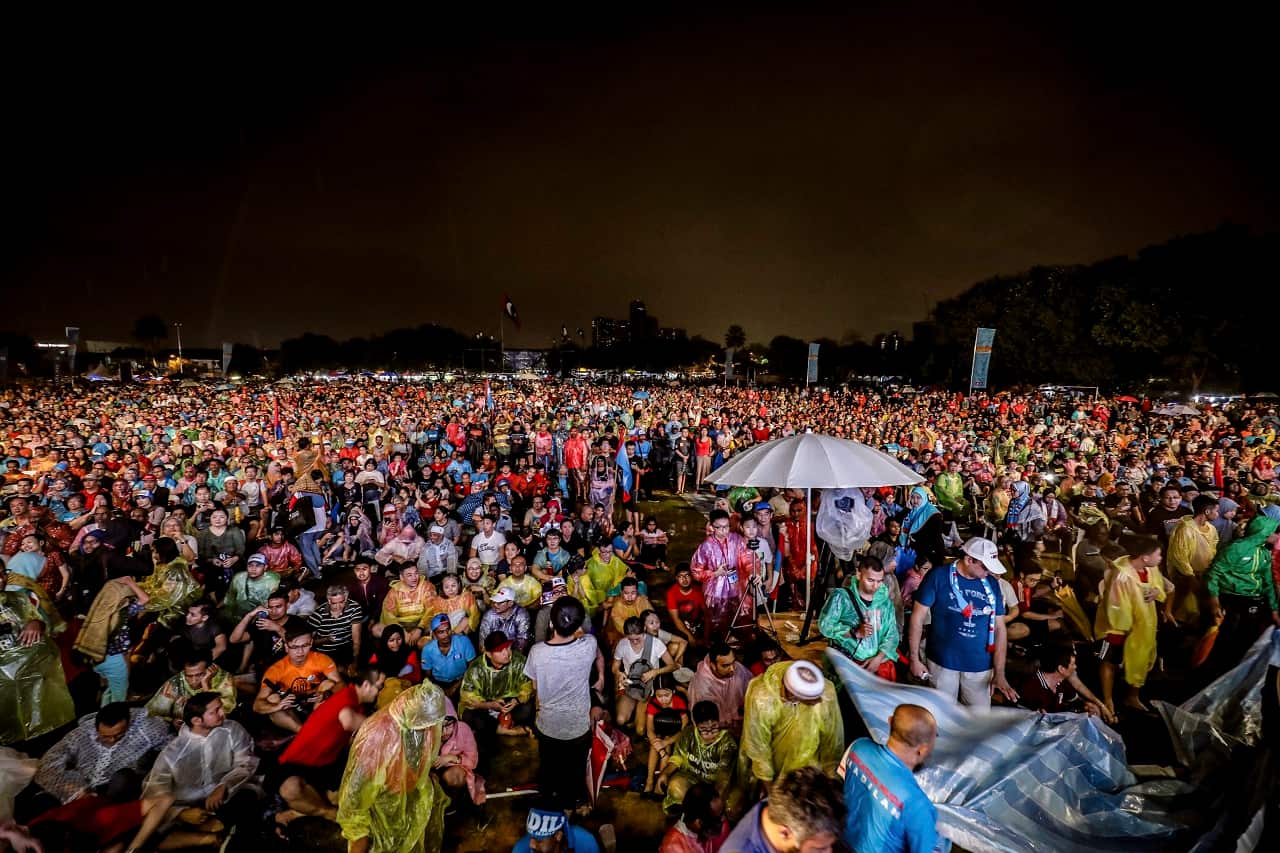 Supporters of former Malaysian strongman Mahathir Mohammad wait as rain pours during an election campaign in Kuala Lumpur,