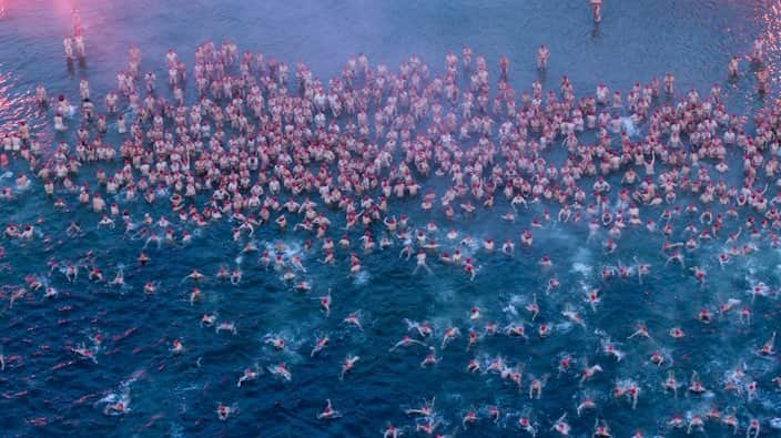 Participants of the Dark Mofo Nude Solstice Swim are seen in the River Derwent at dawn, in Hobart, Friday, June 22, 2018. (AAP Image/Rob Blakers) NO ARCHIVING