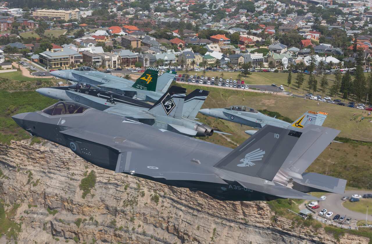 Royal Australian Air Force F/A-18 Hornets fly in formation with an F-35A Joint Strike Fighter over Newcastle, NSW