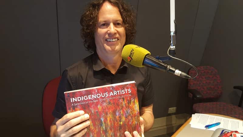 Kent Morris with Indigenous art book