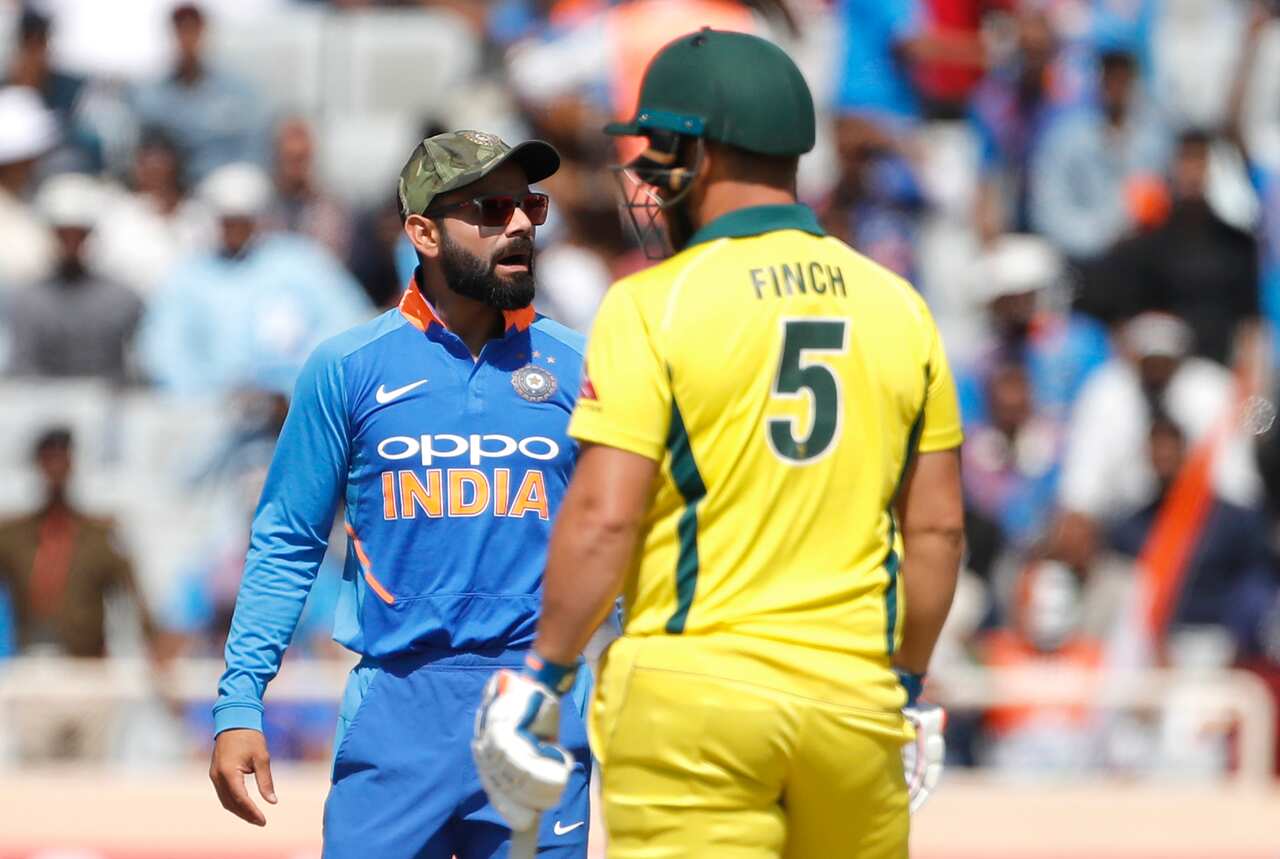 India's captain Virat Kohli, left, interacts with teammates before asking for a review for the wicket of Australia's captain Aaron Finch, right.