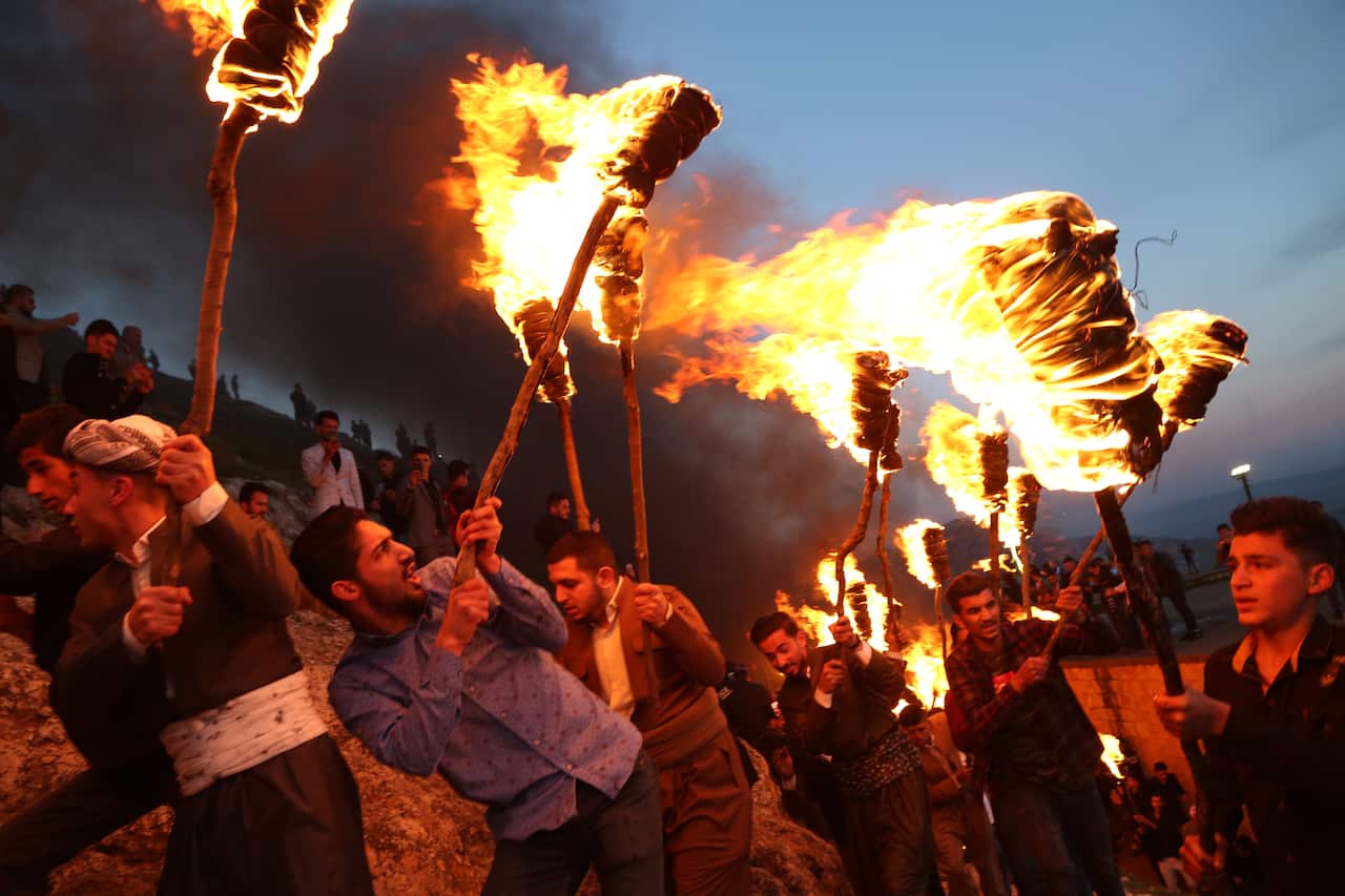 People participate in a torch procession during celebrations of the Kurdish New Year Nowruz in Akre, Aqrah City in Duhok, Kurdistan Region, northern Iraq.