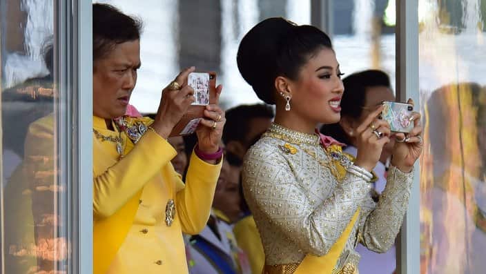 The king's daughter Princess Sirivannavari Nariratana (R) and king's younger sister Princess Maha Chakri Sirindhorn (L) taking pictures during Thai's King Maha Vajiralongkorn Bodindradebayavarangkun procession to circle the city