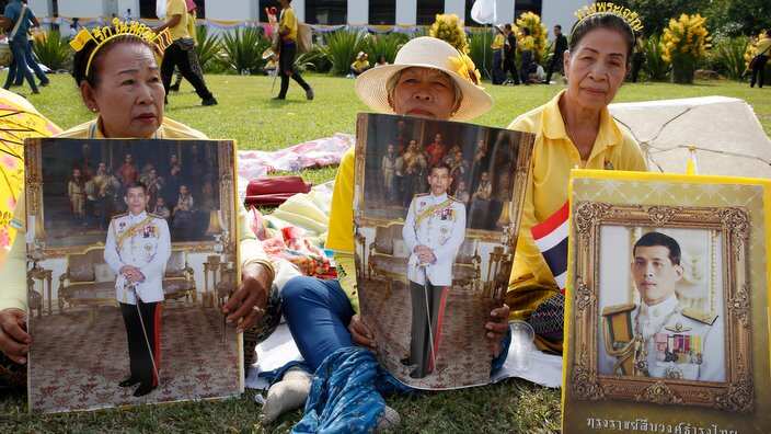 Thai well-wishers hold portraits of Thai King Maha Vajiralongkorn Bodindradebayavarangkun as they wait to honor him during the royal coronation ceremony, outside the Grand Palace in Bangkok, Thailand, 06 May 2019.
