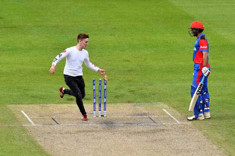 A pitch invader knocks off the bails during the ICC Cricket World Cup group stage match at Old Trafford, Manchester.