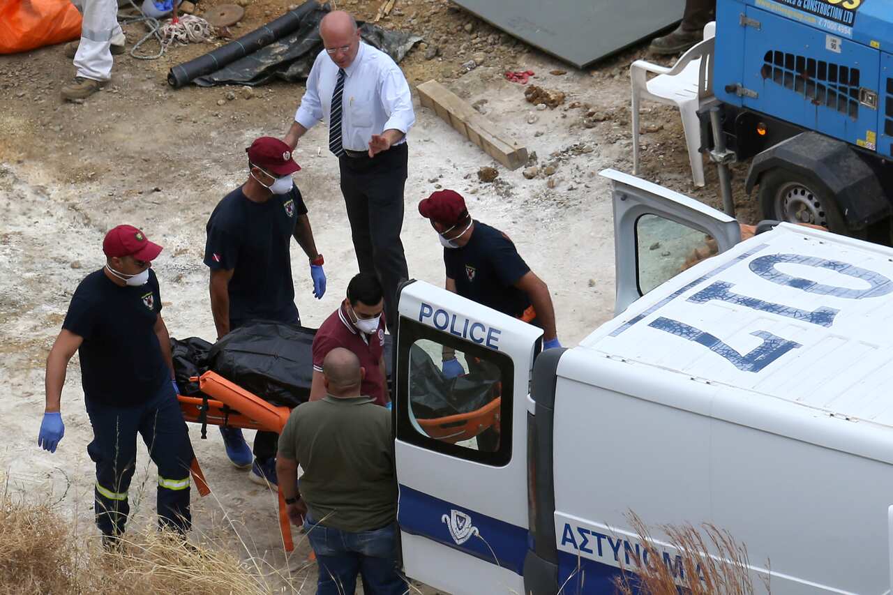 In this photo taken on Tuesday, June 4, 2019, Cyprus' Special Disaster Response Unit investigators carry a covered suitcase on a stretcher after it was retrieved from a man-made lake near the village of Mitsero, outside of the capital Nicosia, Cyprus. A C