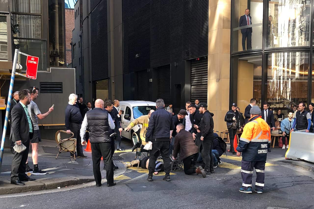 A supplied image obtained Tuesday, August 13, 2019 shows members of the public restraining an individual in Sydney