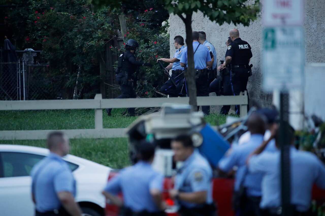 Police officers stand near the scene of a shooting Wednesday, Aug. 14, 2019, in the Nicetown neighborhood of Philadelphia. (AP Photo/Matt Rourke)