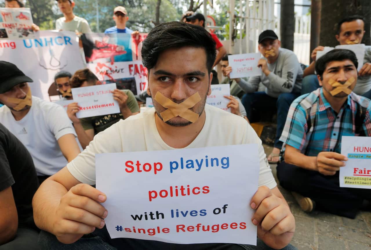 Refugees from various countries hold posters during a protest outside the building that house UNHCR representative office in Jakarta, Indonesia, Tue 20/8/2019.