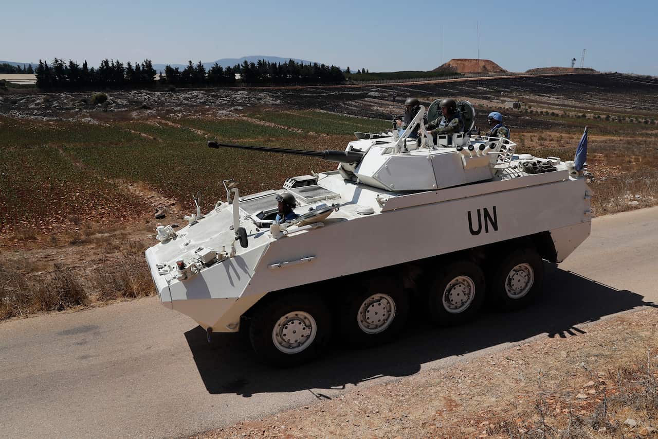 Irish UN peacekeepers use an armored patrol vehicle patrol near the fields struck by Israeli army shells in the southern Lebanese-Israeli border