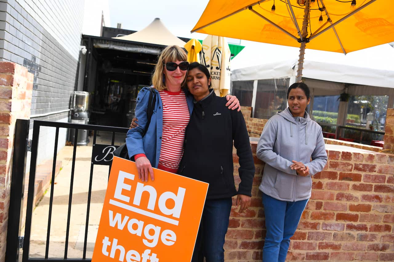 Former employees Shojin Thomas (centre) and Ninumol Abraham are seen near the Indian Restaurant Binny's Kathitto in Canberra, Wednesday, September 5, 2019. Former employees allege the restaurant forced staff to pay back wages. 