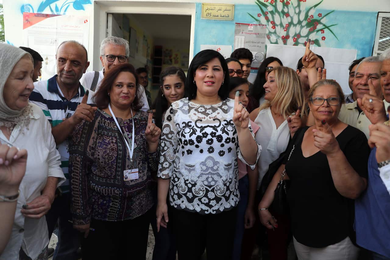 Tunisia's presidential candidate Abir Moussi (C) of the Free Destourian Party (PDL) poses for a photo at a polling station