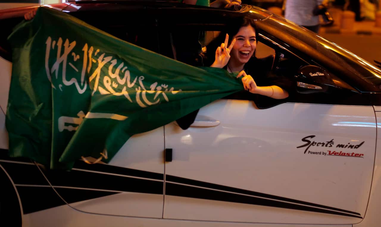 Saudis wave national flags as they hang out the window of a car during celebrations marking National Day to commemorate the unification of the country as the Kingdom of Saudi Arabia, in Riyadh, Saudi Arabia, Monday, Sept. 23, 2019. (AP Photo/Amr Nabil)