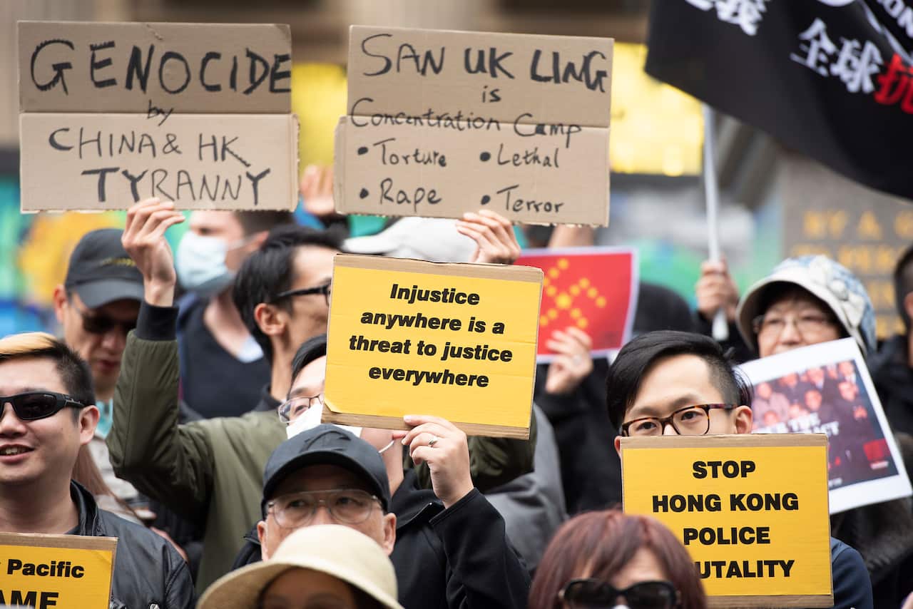 Pro-democracy supporters stand on the steps of the State Library during a Hong Kong pro-democracy demonstration in Melbourne, Sunday, September 29, 2019. (AAP Image/Ellen Smith) NO ARCHIVING