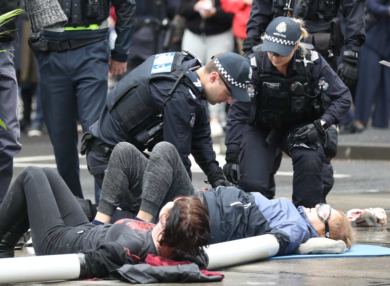 Activists from Extinction Rebellion participate in a protest in Melbourne on Kings Way where some protesters have glued themselves to the road