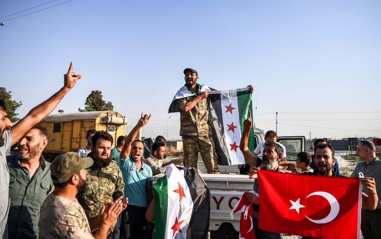 Turkish-backed Syrian opposition fighters celebrate in Akcakale, in Sanliurfa province advance, after entering over the border from Tal Abyad, Syria, Sunday, Oct. 13, 2019.