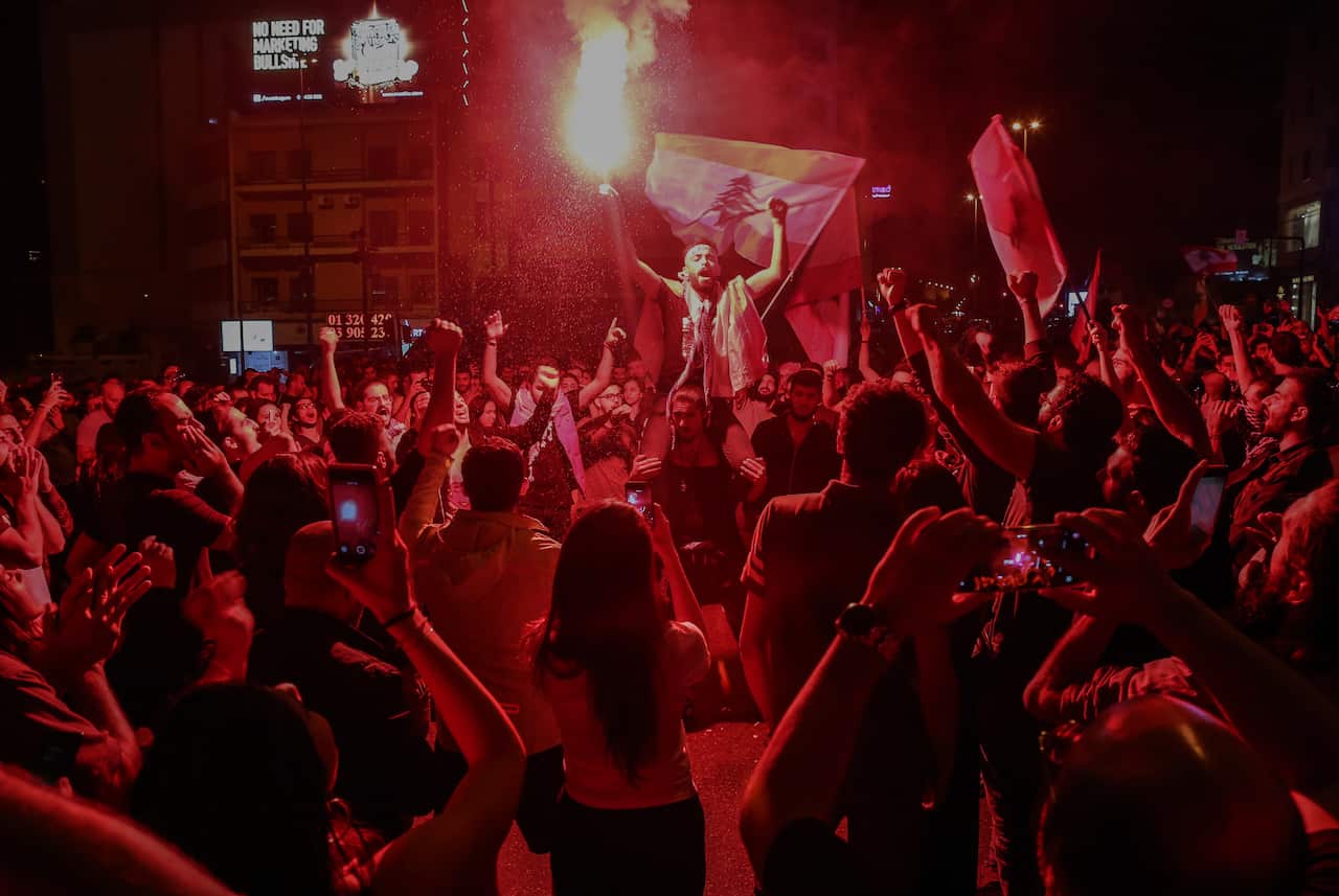 Protesters wave Lebanese flags shout slogans as they block the Ring Bridge highway during a protest in Beirut, Lebanon, 12 November 2019. 