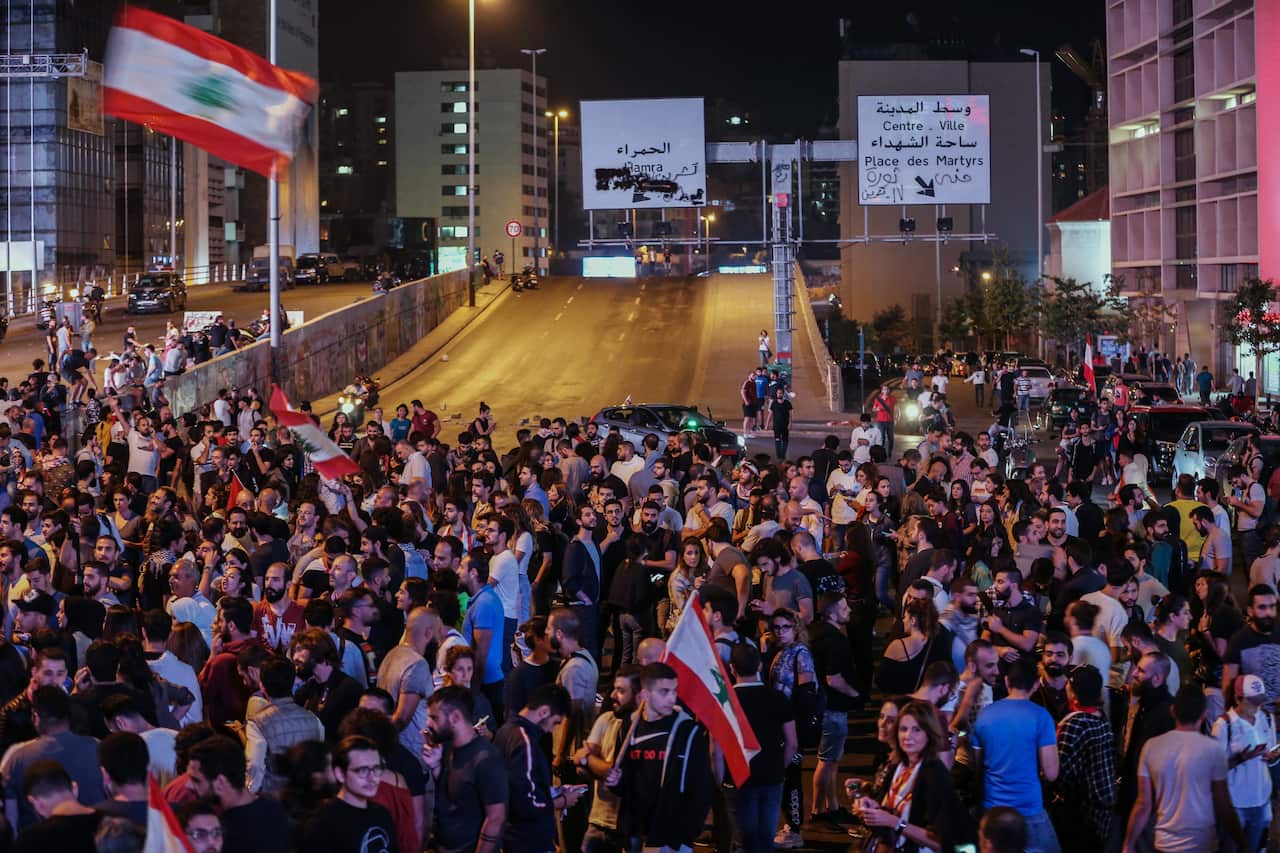 Protesters wave Lebanese flags shout slogans as they block the Ring Bridge highway during a protest in Beirut, Lebanon, 12 November 2019. 