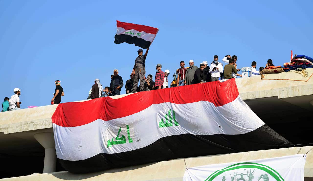Iraqi protesters carry the Iraqi national flag as they gather over a parking complex near the Al Khilani square, in central Baghdad, Iraq, 17 November 2019.