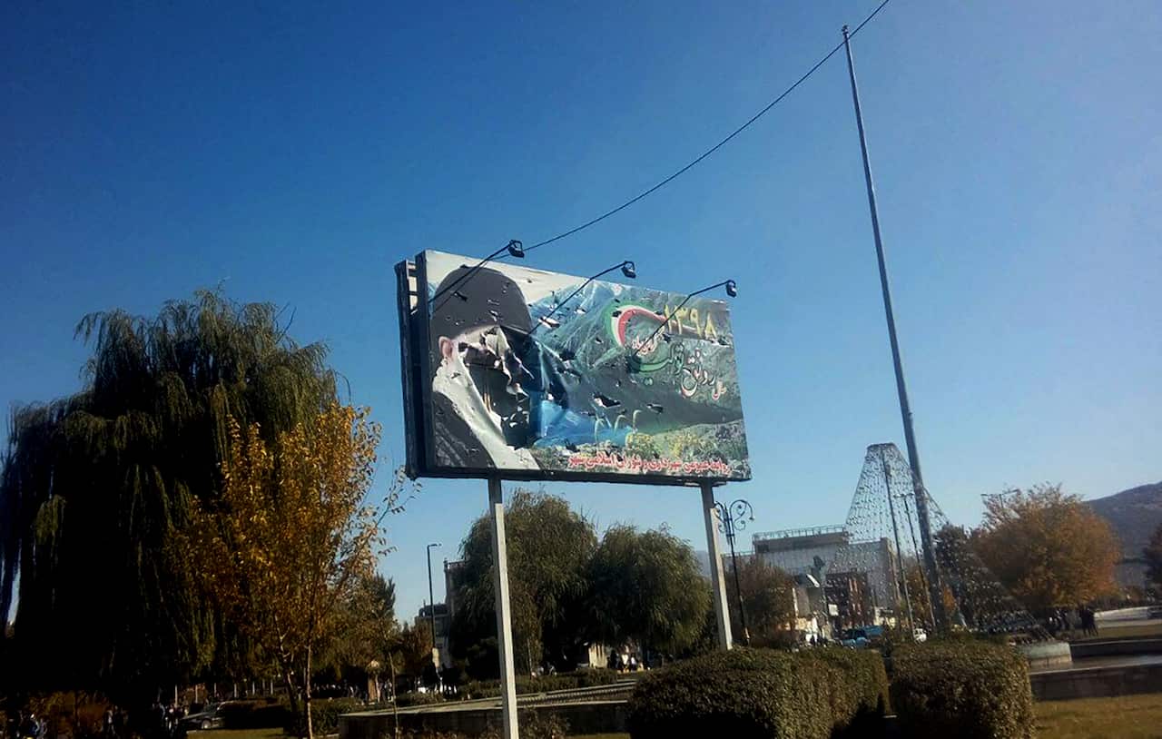 Iranian protesters destroyed a banner of Iran's Supreme Leader Ayatollah Ali Khamenei during a demonstration against an increase in gasoline prices.