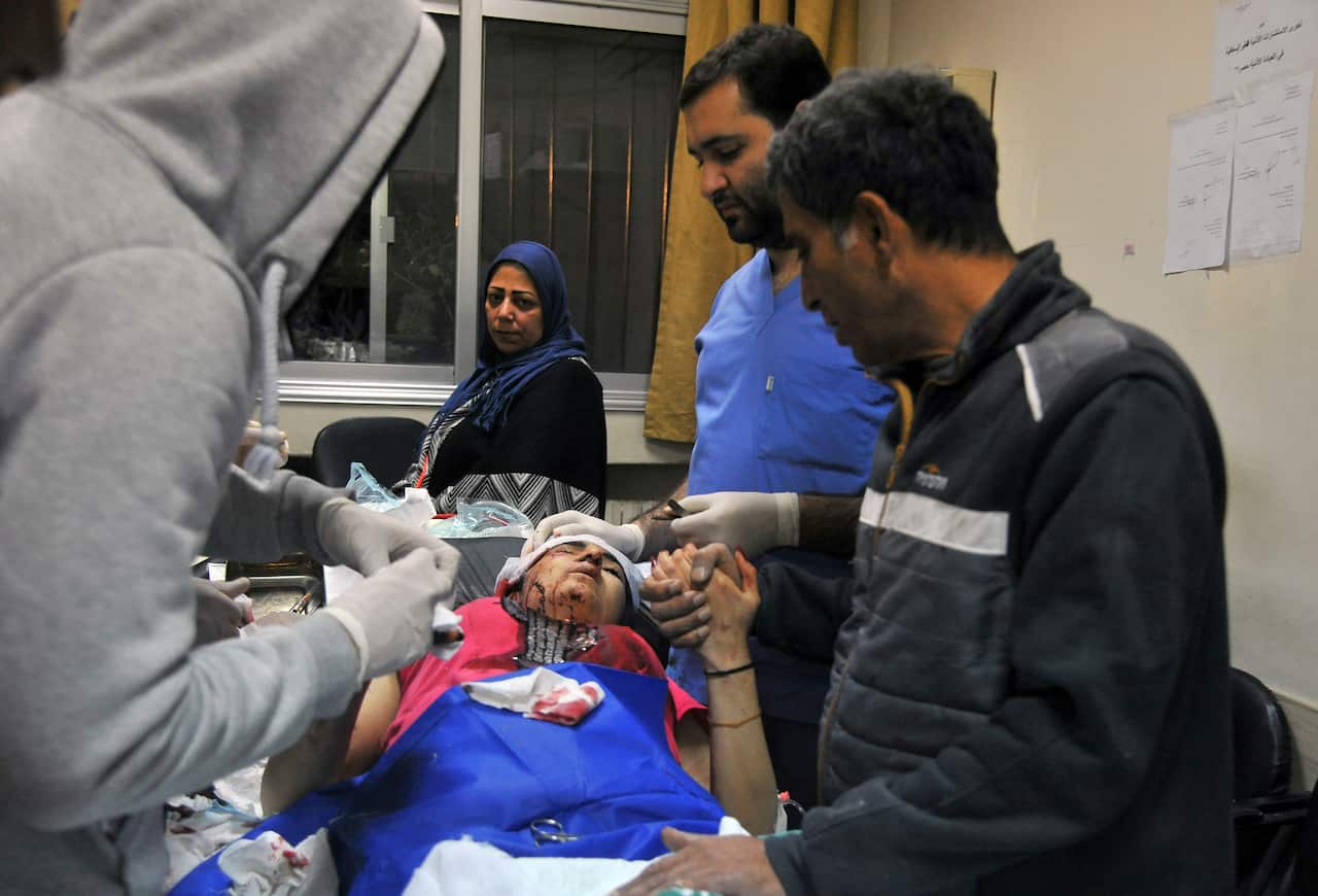 A paramedic treats an injured woman wounded by Israeli missile strikes at a hospital in Damascus, Syria, Wednesday, Nov. 20, 2019.