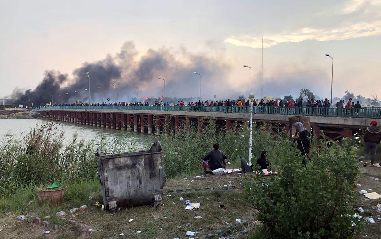 Smoke clouds rise from a military base which was reportedly stormed by Iraqi protesters during clashes with security forces in Nasiriyah city