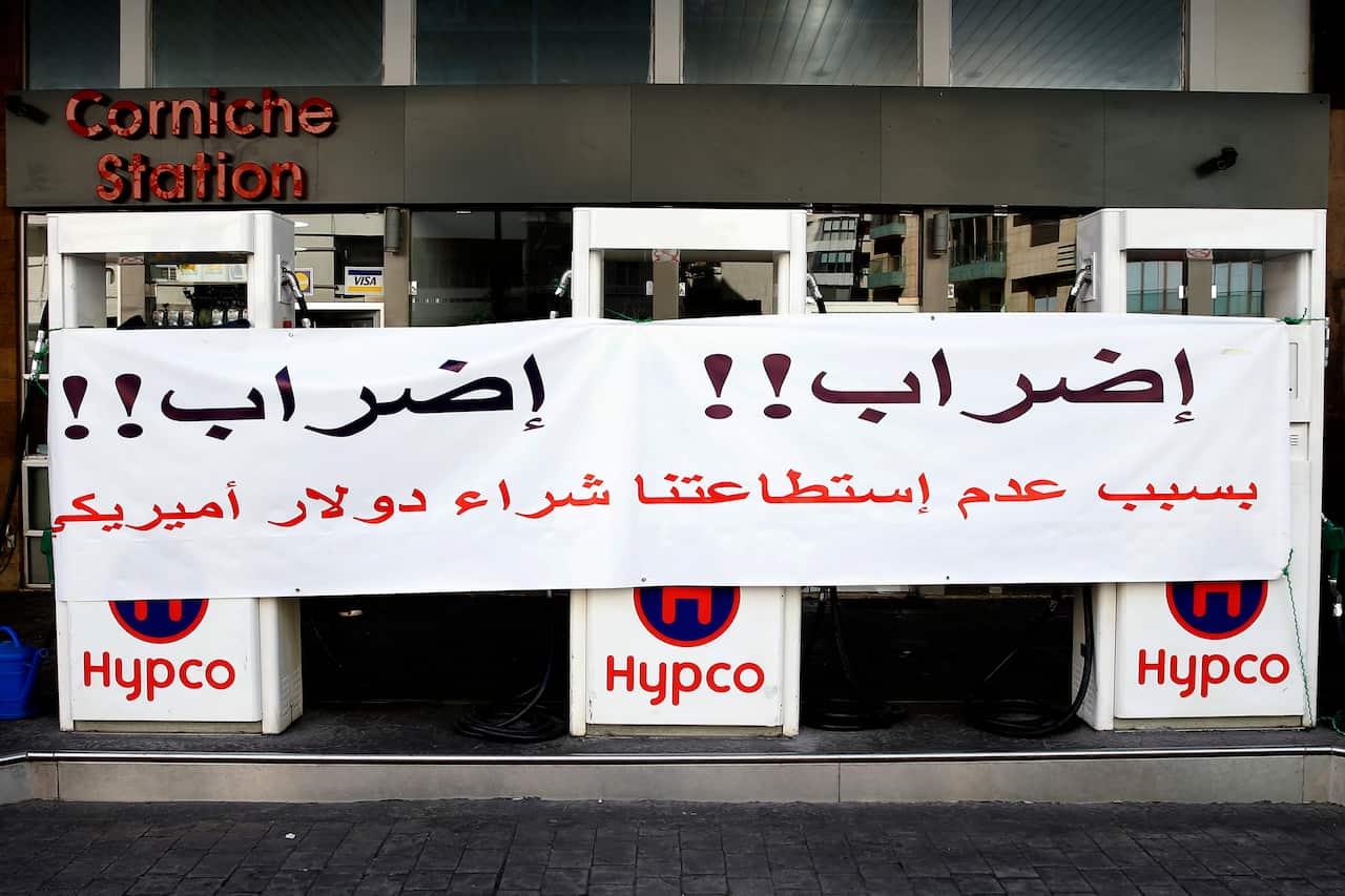 A gas station pump is closed during a protest against tight supply of dollars from the central bank in Beirut, Lebanon, Friday, Nov. 29, 2019.