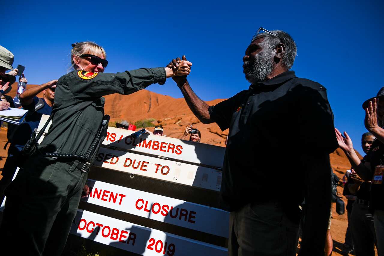 Mlinzi Lynda Wright (kushoto) na Mwenyekiti wa baraza la Uluru-Kata Tjuta Sidney James (kulia) waamkiana baada yakutekelezwa kwa marufukuyakupanda Uluru