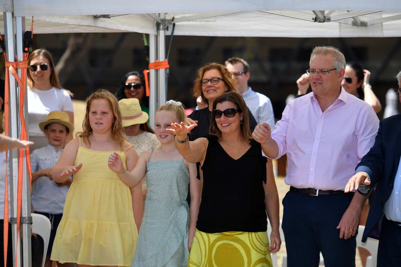 Prime Minister Scott Morrison, wife Jenny and daughters Abbey and Lily dance during an indigenous water blessing ceremony in Canberra, Saturday, January 25, 2020. (AAP Image/Mick Tsikas) NO ARCHIVING