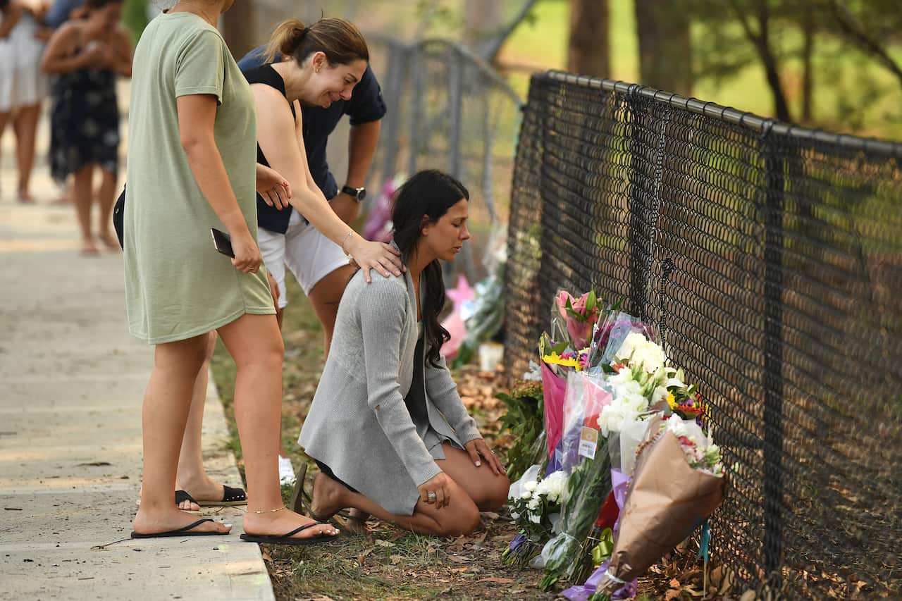 The victims' mother Leila Geagea (right) pauses near flowers placed at the scene where seven children were hit on a footpath by a four-wheel drive in the Sydney suburb of Oatlands