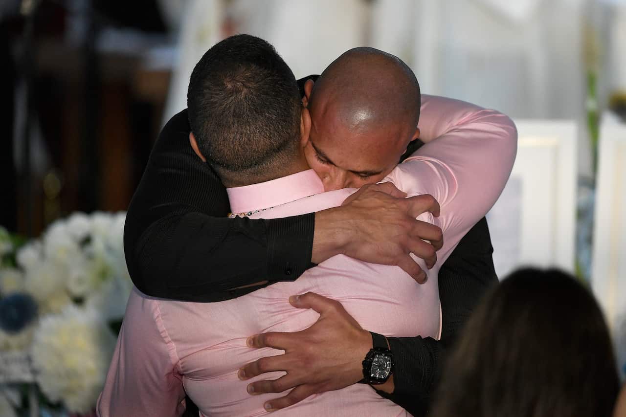 Danny Abdallah is comforted during the funeral by Rabea Al Deheny from Liverpool