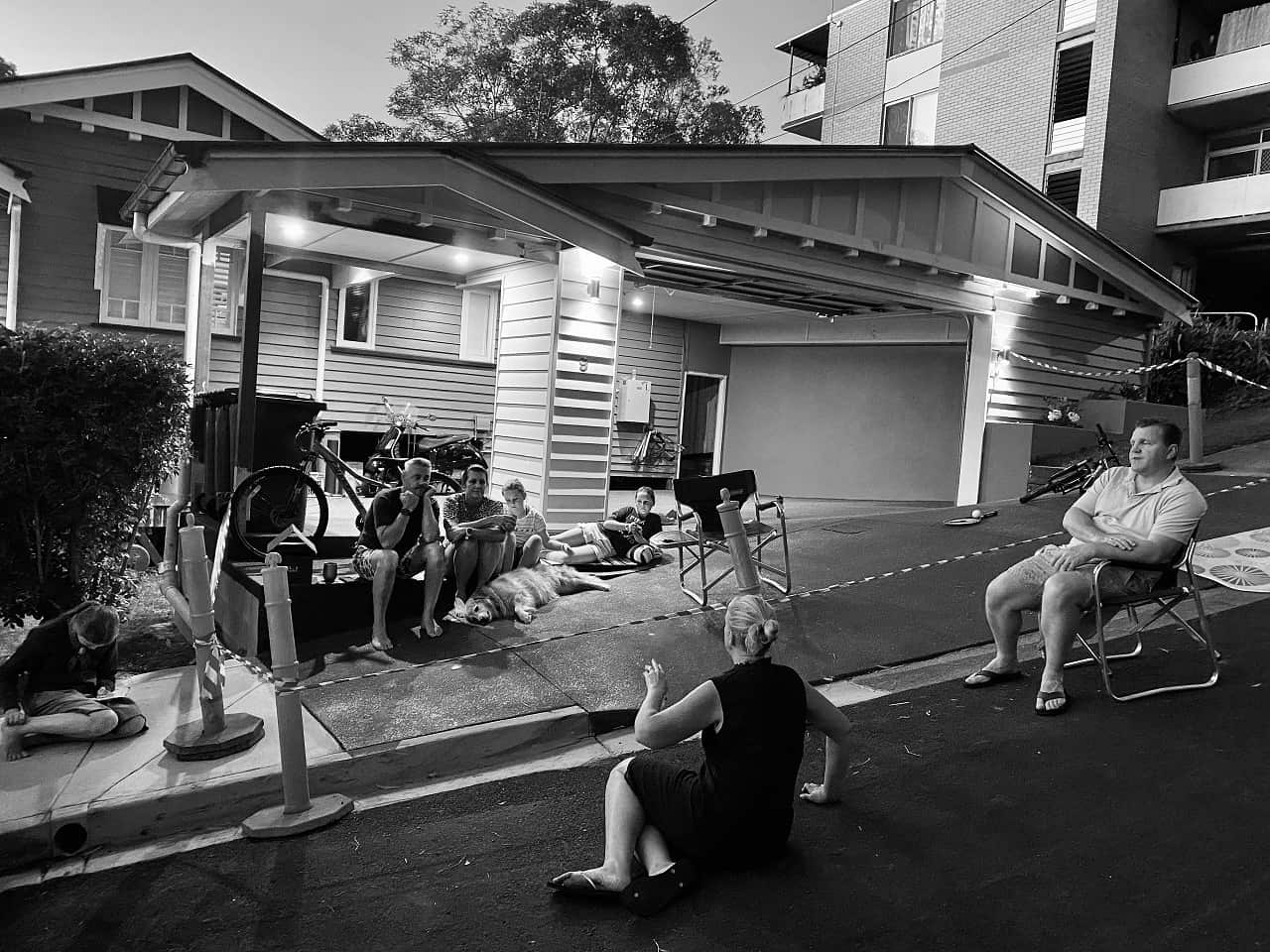 Neighbours discuss the coronavirus pandemic while practicing a safe distance from each other in Brisbane, March 20, 2020. 